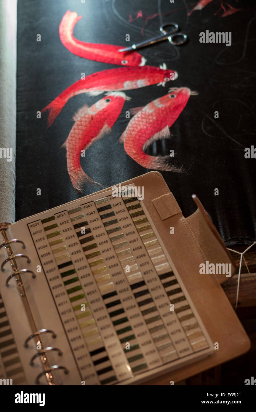 Work in progress silk embroidery of koi carp with the creators tools and colour chart Stock Photo