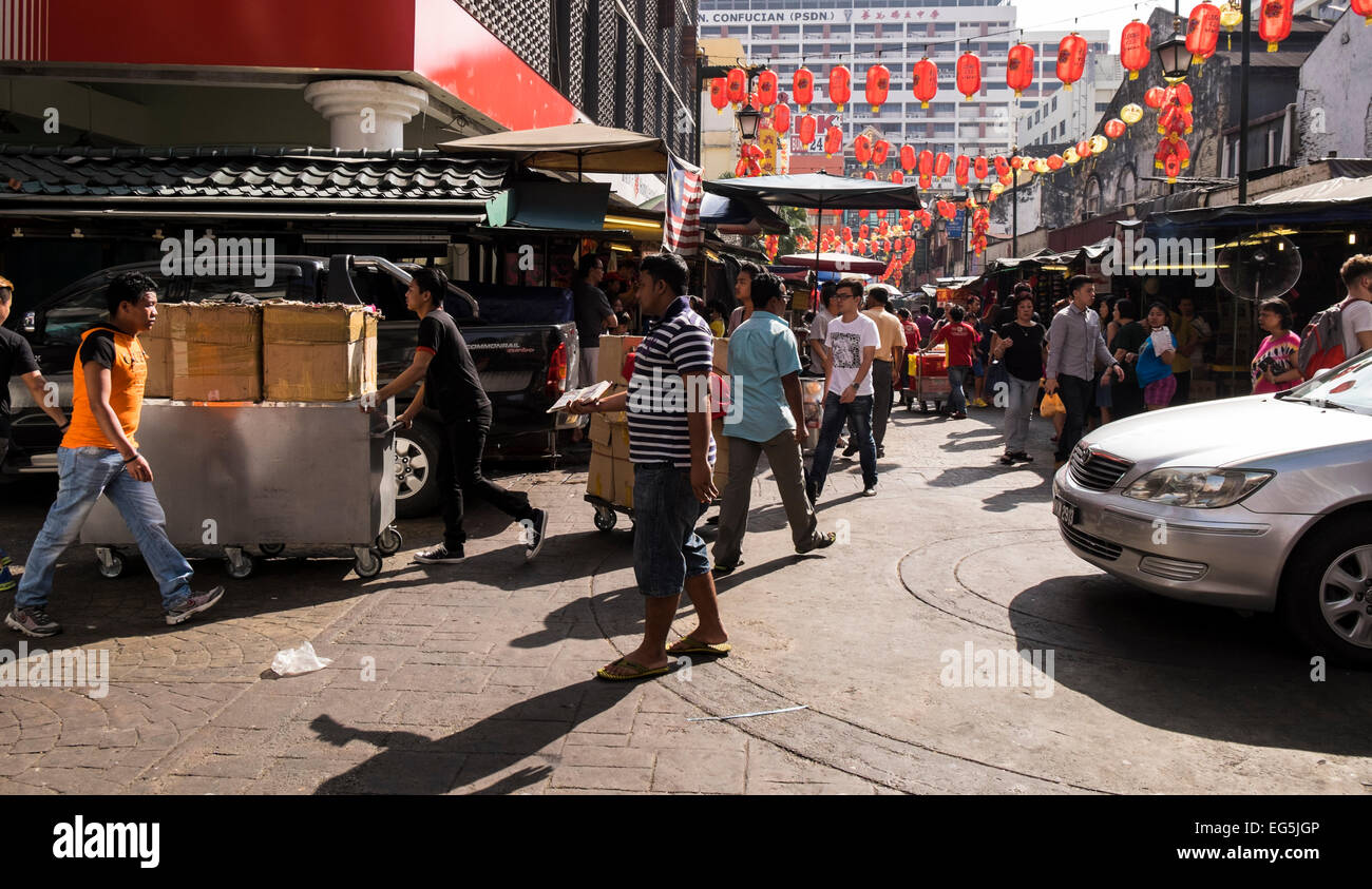 Chinese New Year decorations and hustle and bustle of pedestrians and vehicles in Chinatown, Kuala Lumpur, Malaysia. Stock Photo