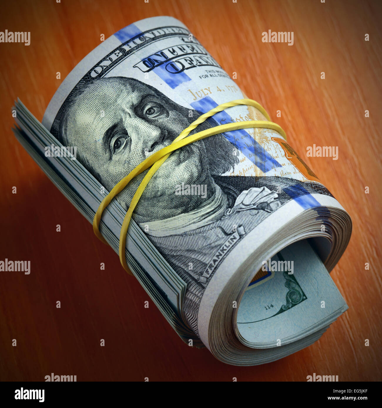 Roll of dollar bills - Money keeps silent Stock Photo