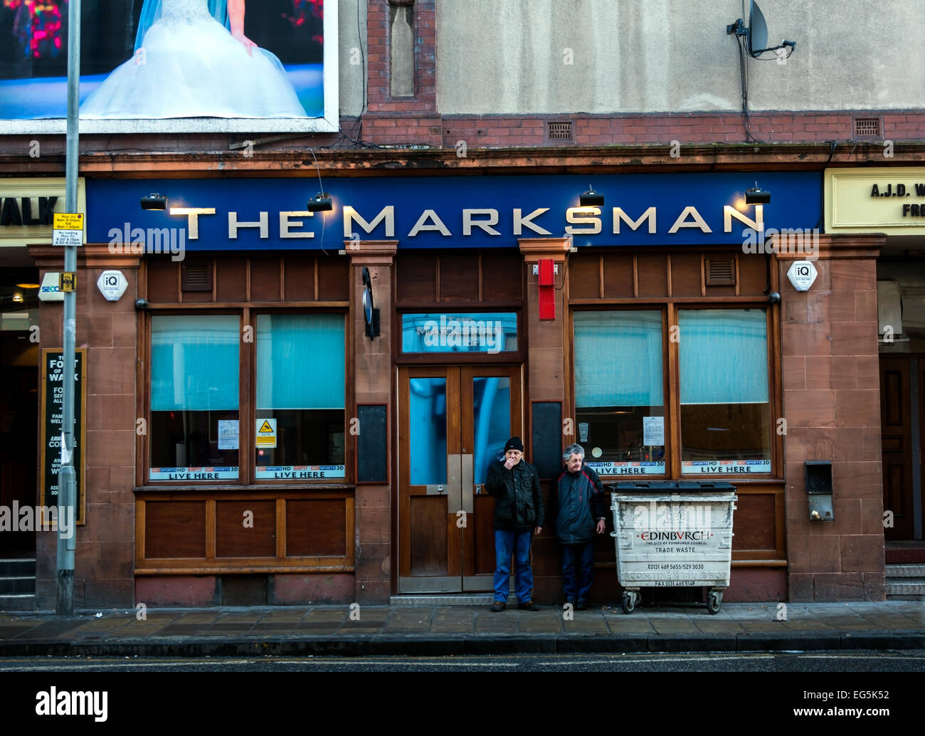 Two men smoking outside the Marksman Bar in Leith, Edinburgh. Stock Photo