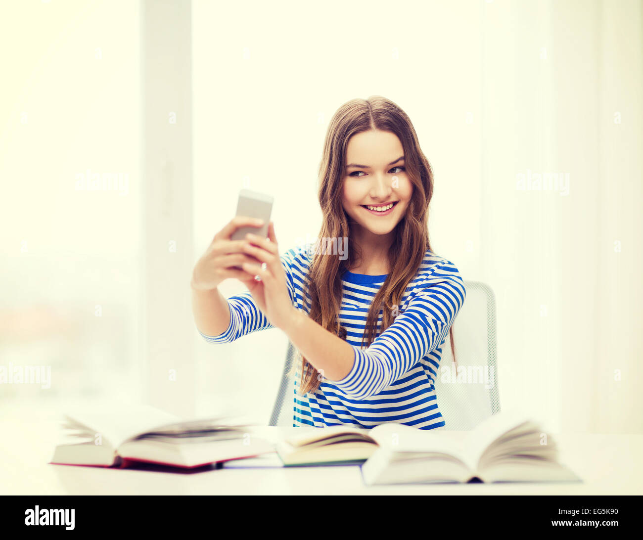 smiling student girl with smartphone and books Stock Photo - Alamy
