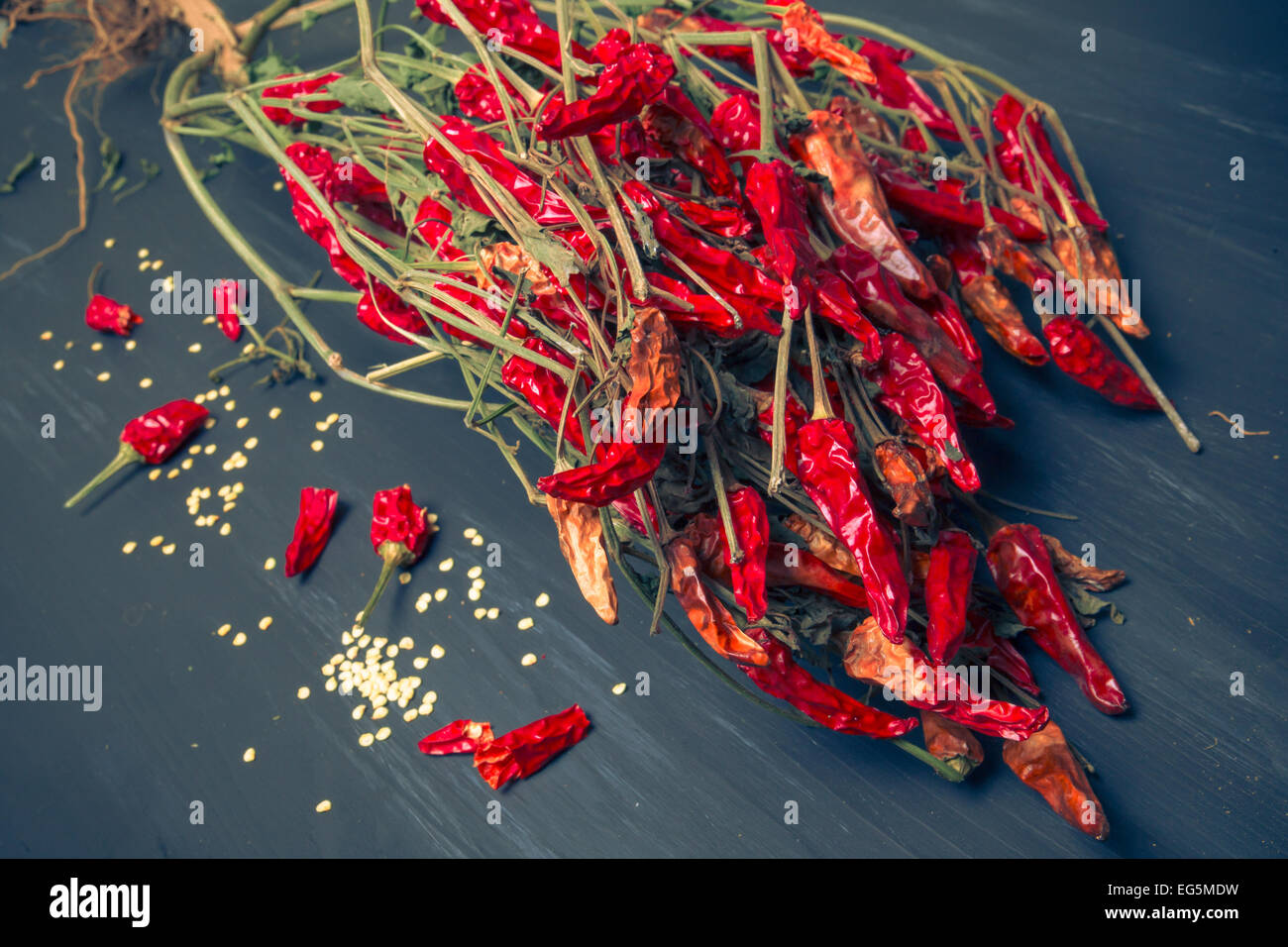 Bunch of hot red chili peppers and seeds on wood background Stock Photo