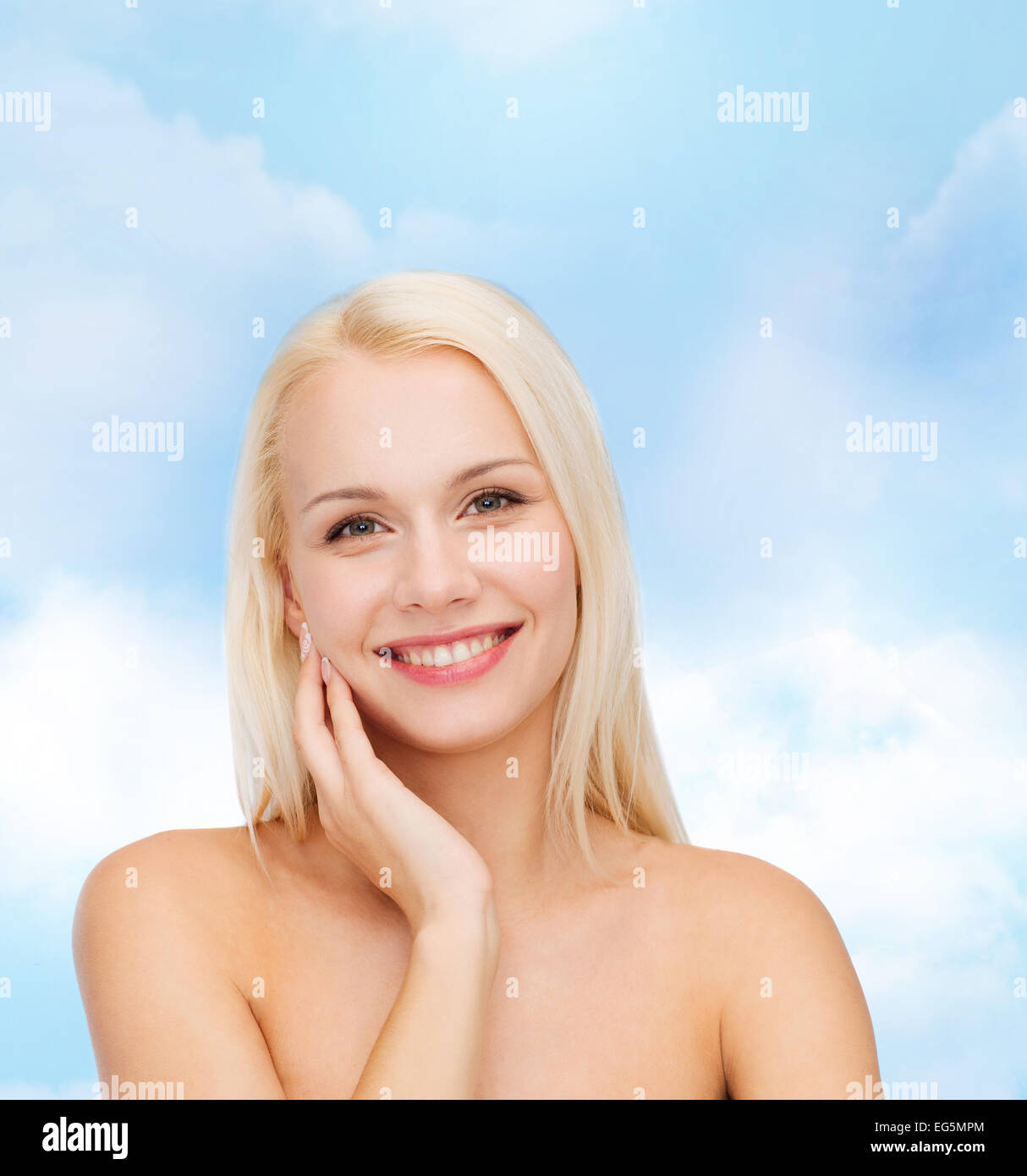 smiling young woman touching her face skin Stock Photo - Alamy
