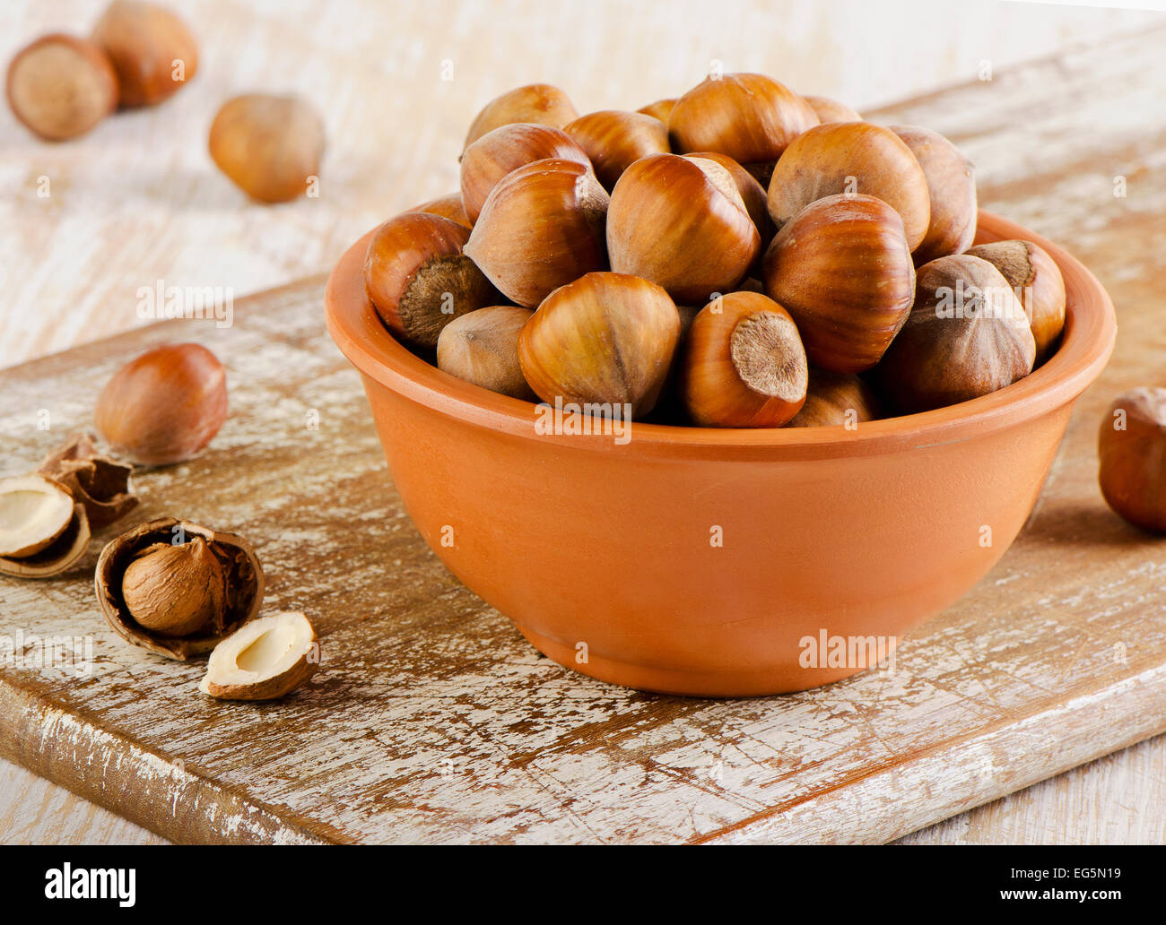 Hazelnuts on old wooden board Stock Photo