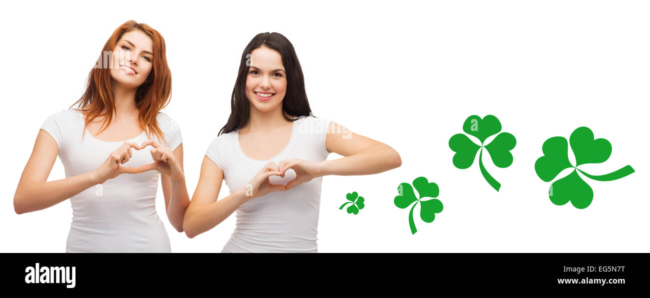smiling girls showing heart gesture with shamrock Stock Photo