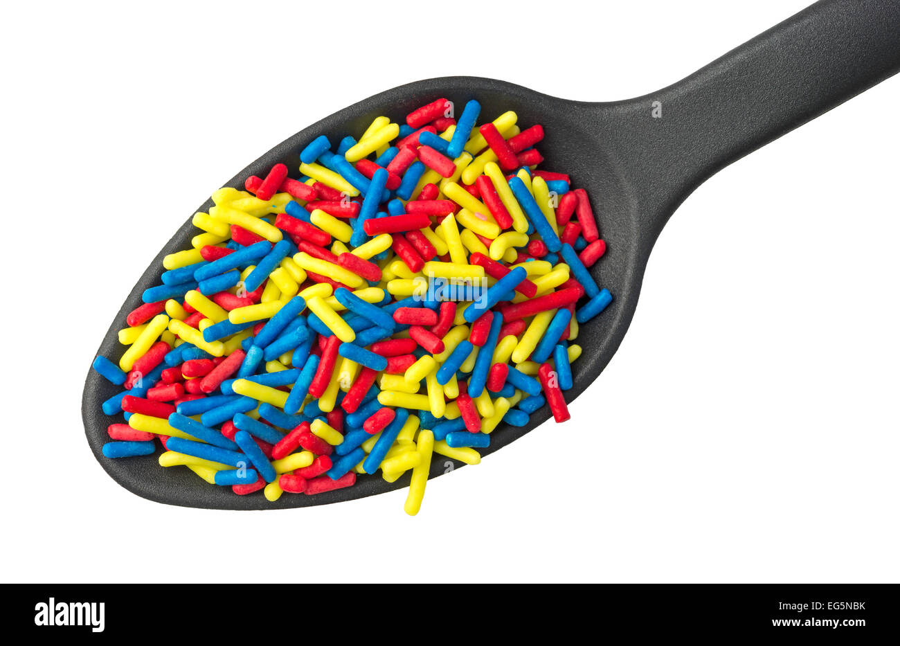 A small spoon filled with colorful candy sprinkles on a white background. Stock Photo