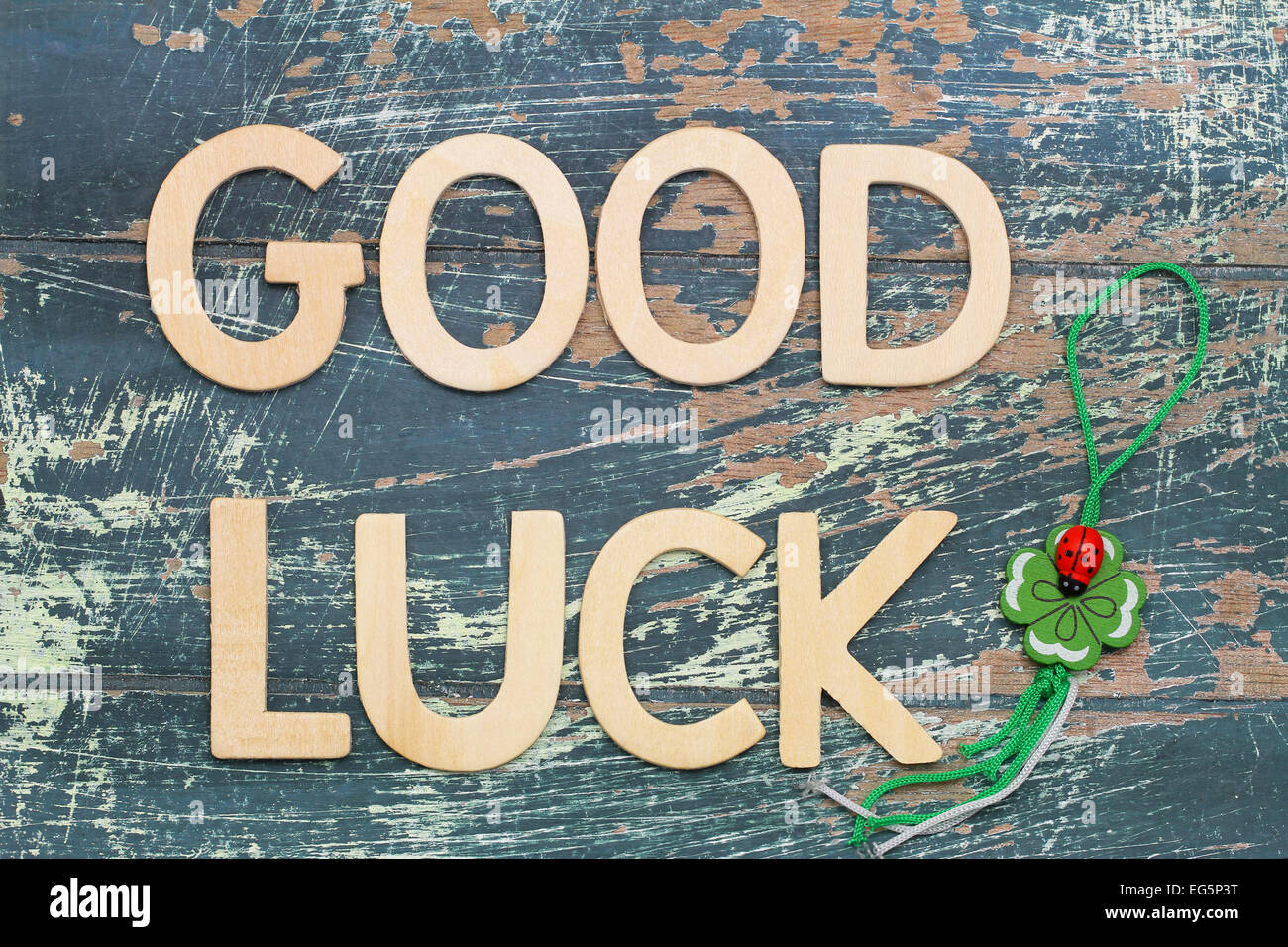 Good luck written with wooden letters on rustic wood and four-leaf clover Stock Photo