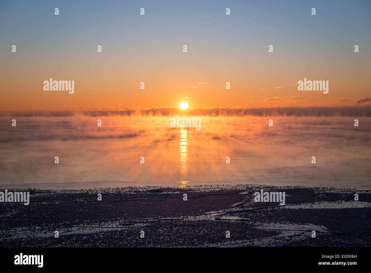 The sun rises above the steaming waters of Lake Ontario as a -25C polar airmass engulfs the Toronto area & eastern North America Stock Photo