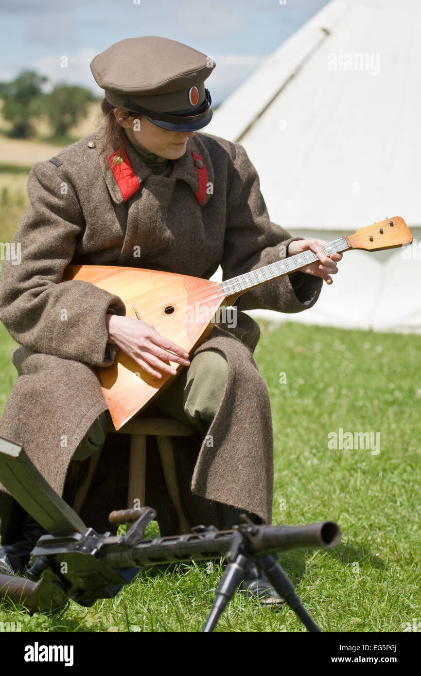 Russian Soldier of a  Womens Battalion of Death 1917 plays the Balalaika. 1914-21 History Society (NB: gun not period compliant) Stock Photo