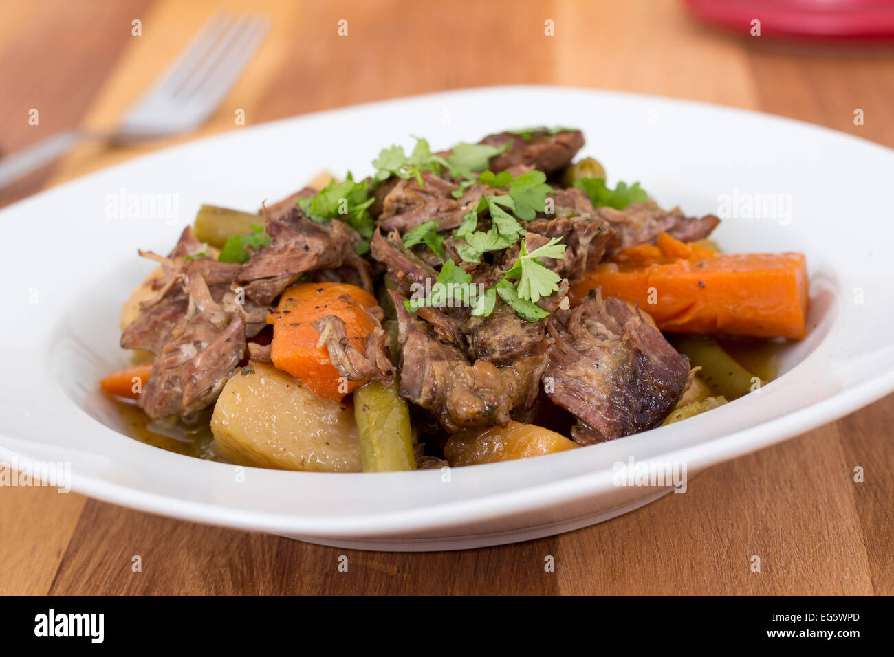 braised beef pot roast stew with vegetables on table Stock Photo