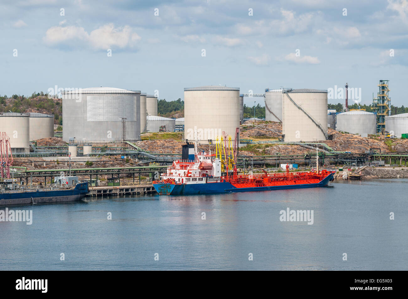 Tanker unloading with oil storage tanks in the background Stock Photo Alamy