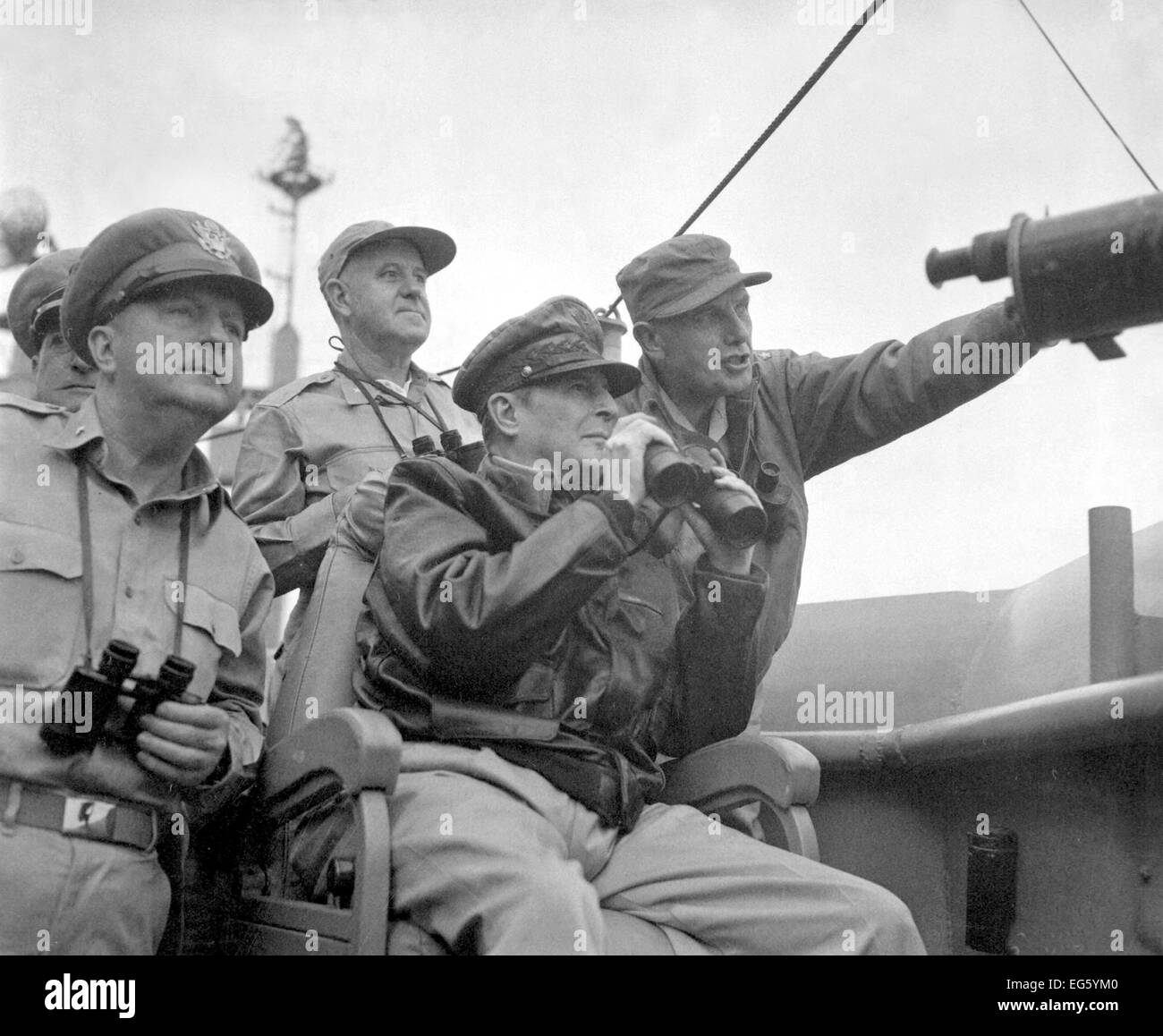 KOREAN WAR (1950-1953) From left: Brig. Gen. Courtney Whitney; Gen. Douglas MacArthur, Commander in Chief of U.N. Forces; and Maj. Gen. Edward M. Almond watch the shelling of Inchon from the U.S.S. Mt. McKinley, September 15, 1950.  Photo: US Army Stock Photo