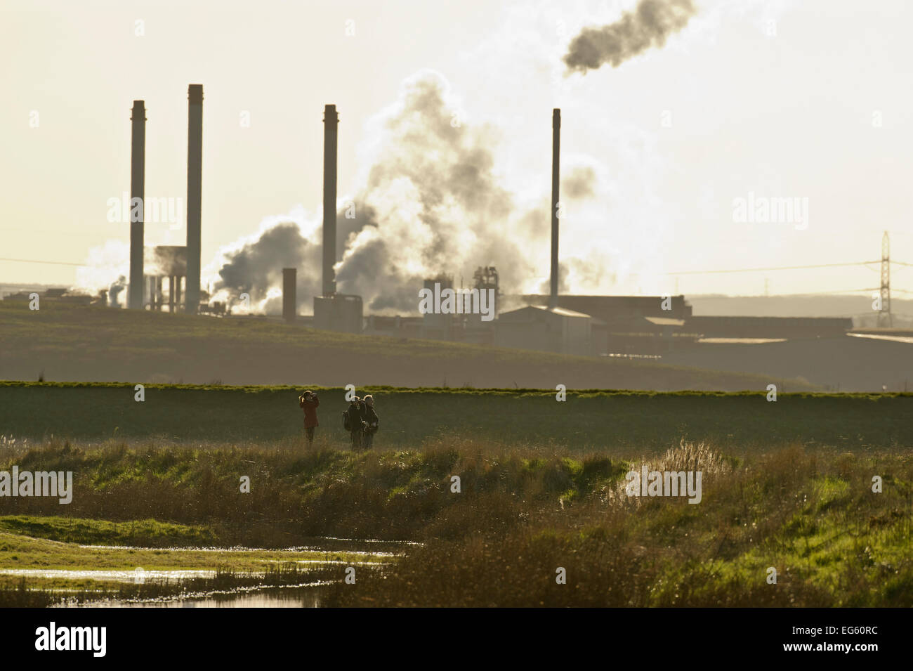 Birdwatchers in foreground with Kemsley Paper Mill in background, Kent, UK, March 2011 Stock Photo