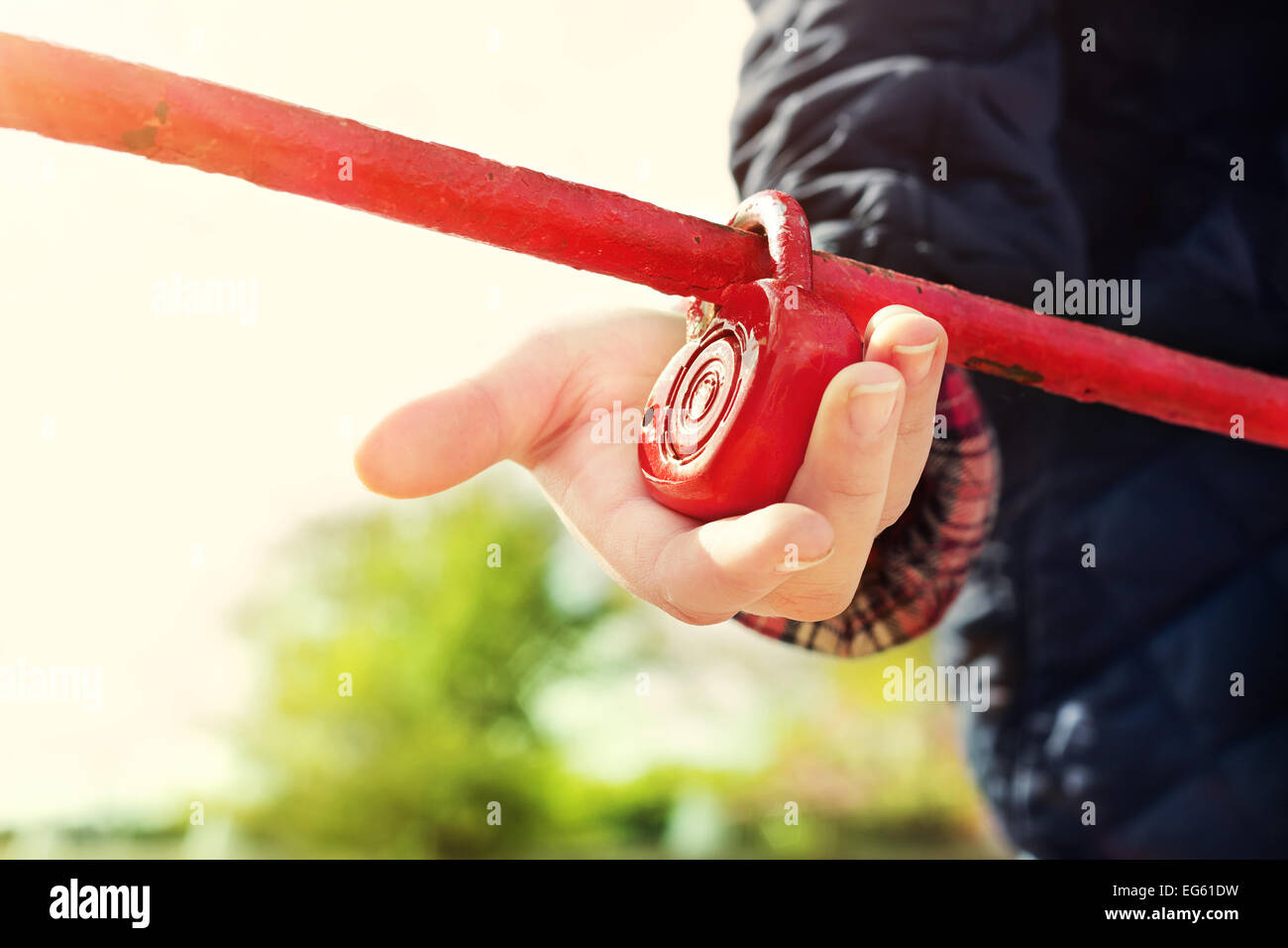 Red heartshaped padlock in hands of girl. Symbol of love, locked on