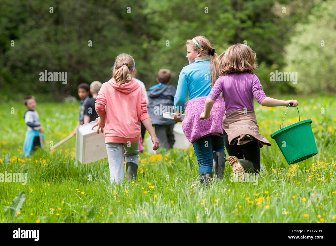 School children carrying equipment to release salmon fry in the River Haddeo and to do invertebrate kick samples with Westcountry Rivers Trust (WRT) warden. Bury, Exmoor National Park, Somerset, UK. May 2012. Editorial use only Stock Photo