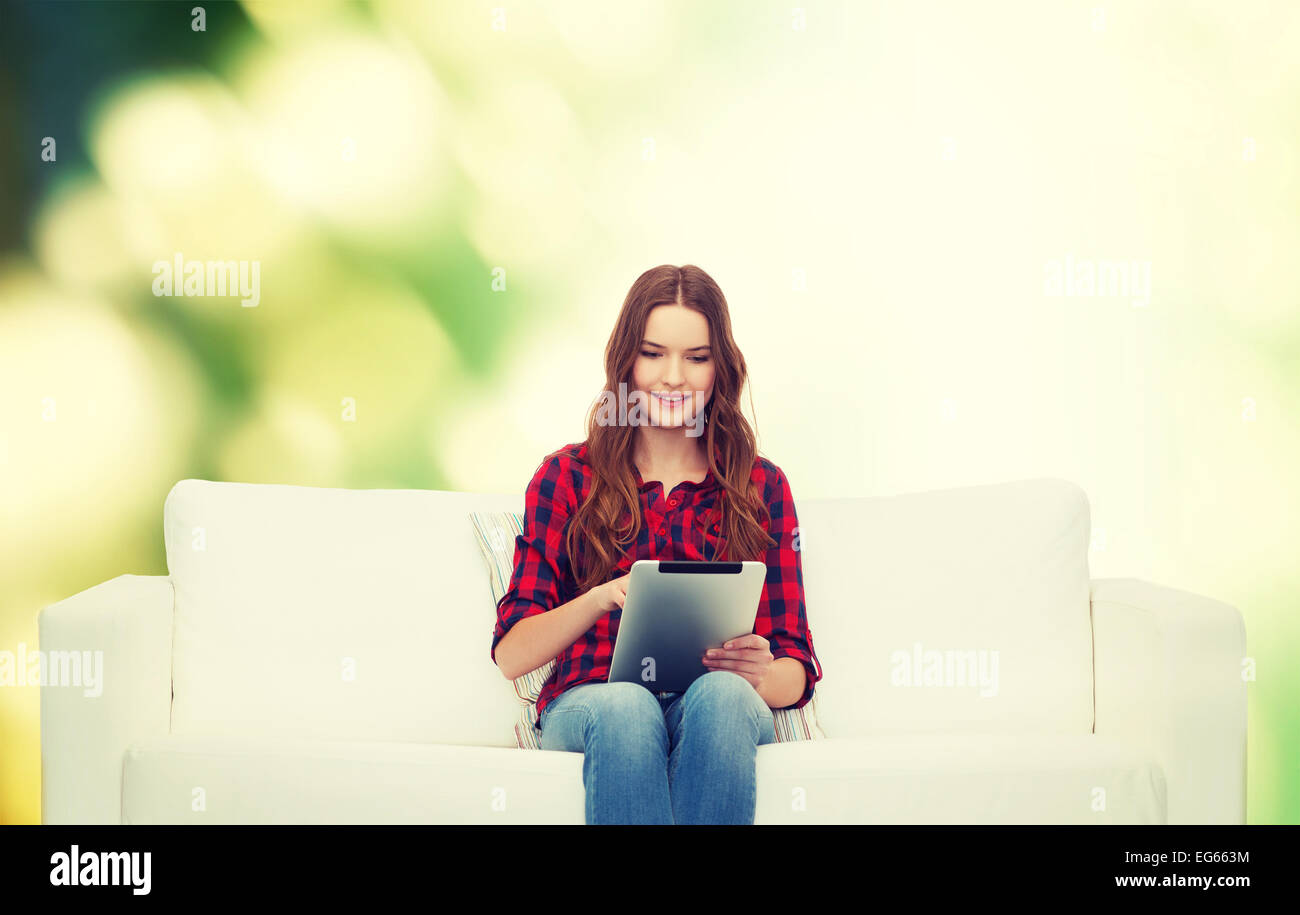 teenage girl sitting on sofa with tablet pc Stock Photo - Alamy