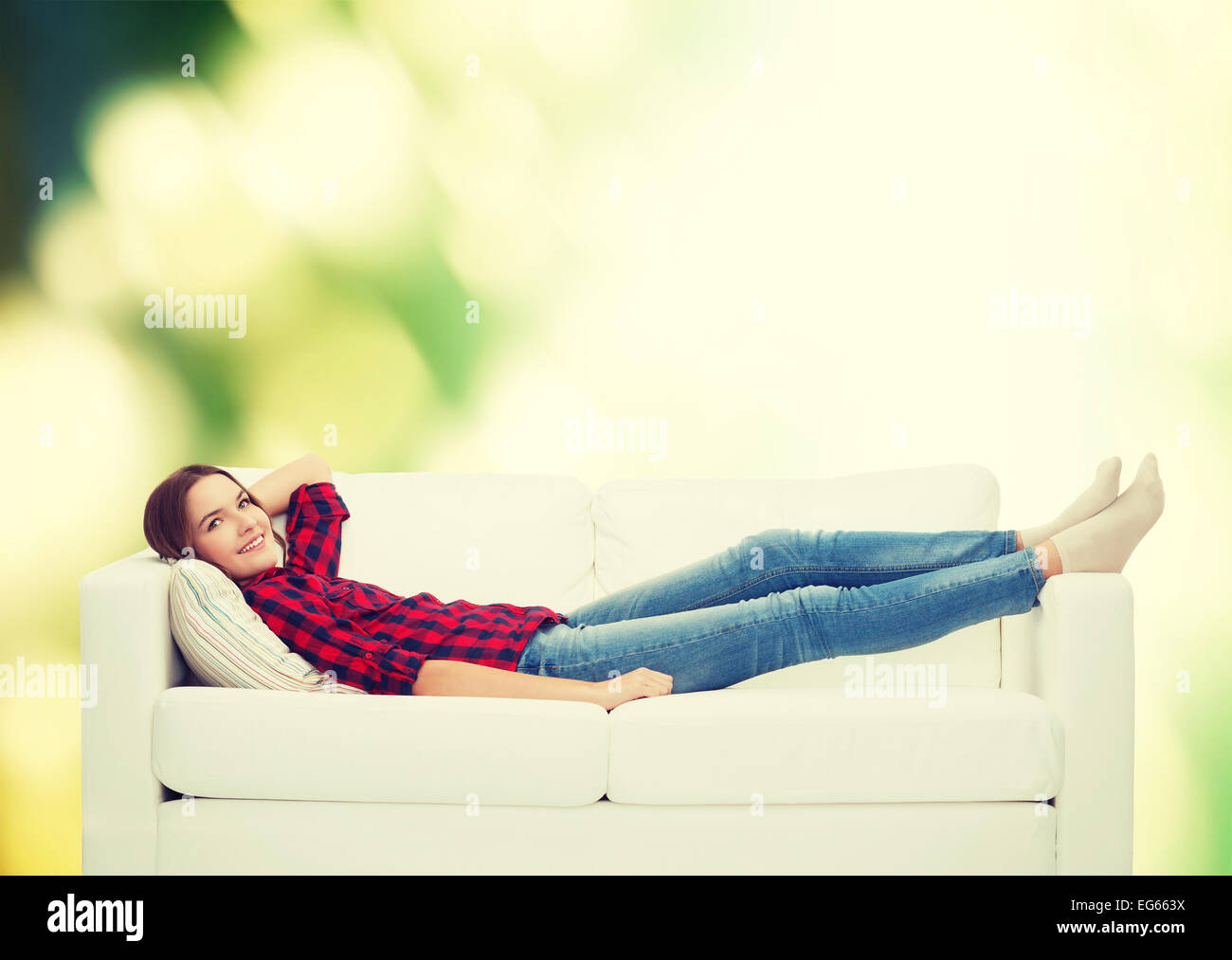 smiling teenage girl lying on sofa Stock Photo - Alamy