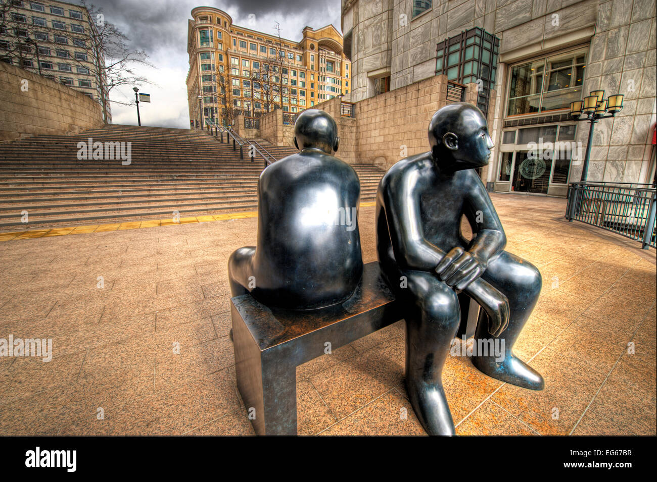 black coloured sculpture of two people sitting on a bench at canary wharf Stock Photo