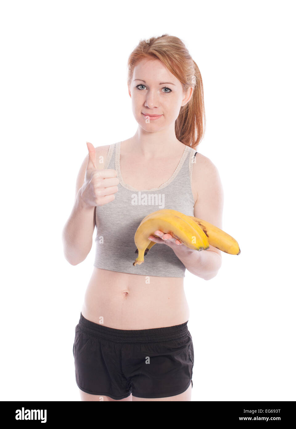 Athletic girl with bananas in hand on white background. Stock Photo