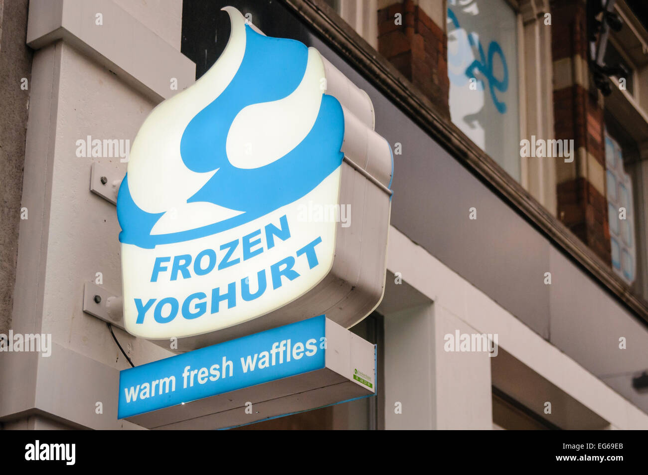 Sign at a shop selling frozen yoghurt on warm, fresh waffles. Stock Photo
