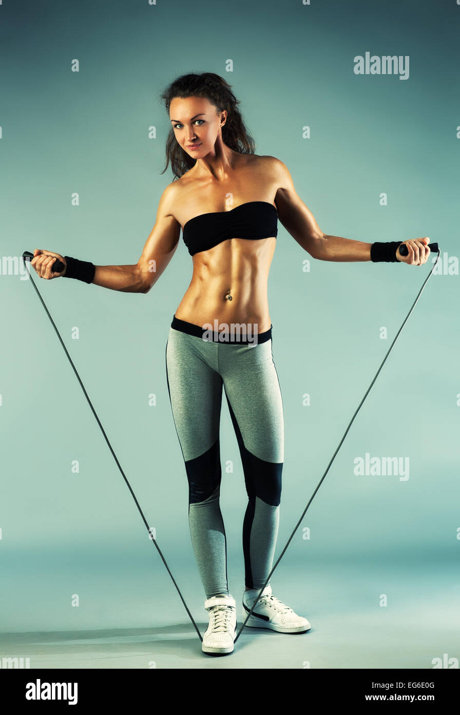 Young sports sexy fitness woman with skipping rope on wall background Stock  Photo - Alamy