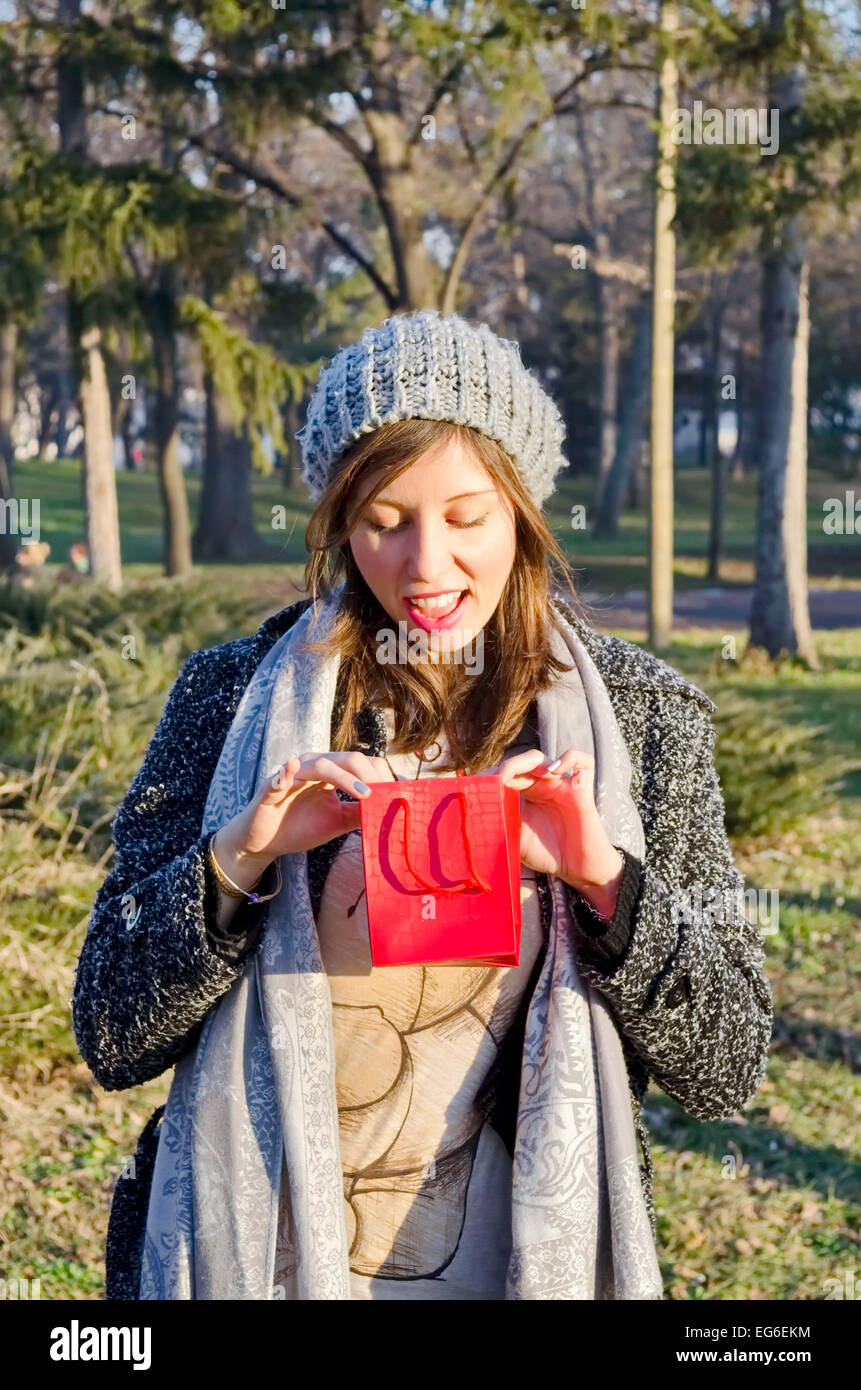 Young girl opening her Valentine's present in a park outdoor Stock Photo
