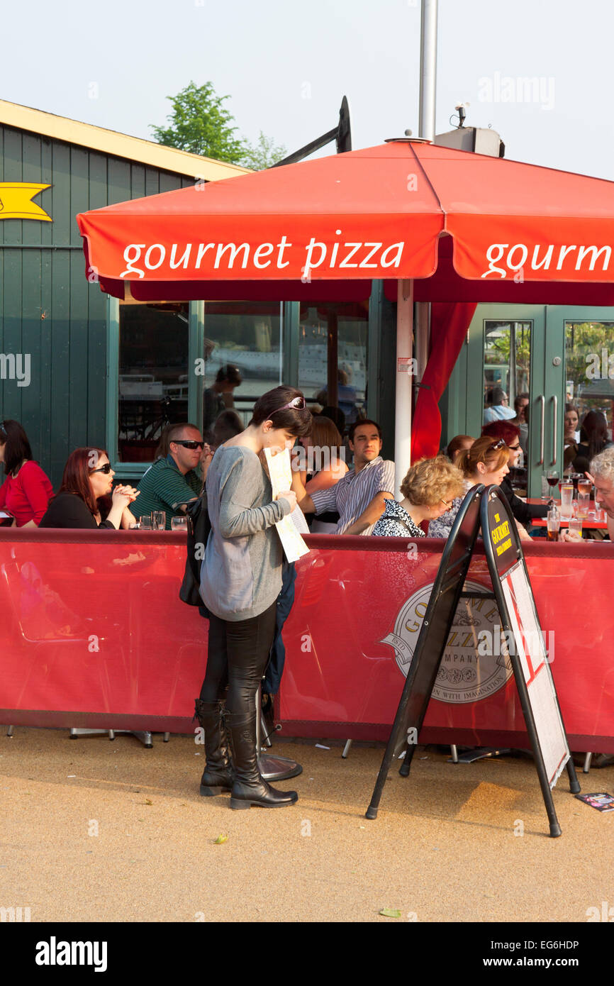 Woman reading menu at Gourmet Pizza restaurant on the South Bank near