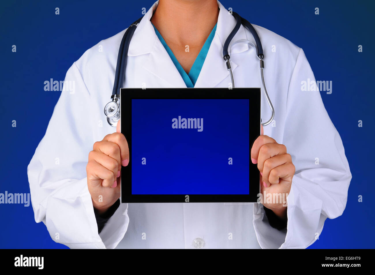 Closeup of a female medical professional holding a tablet computer with a blank blue screen - ready for your copy. Person is unr Stock Photo