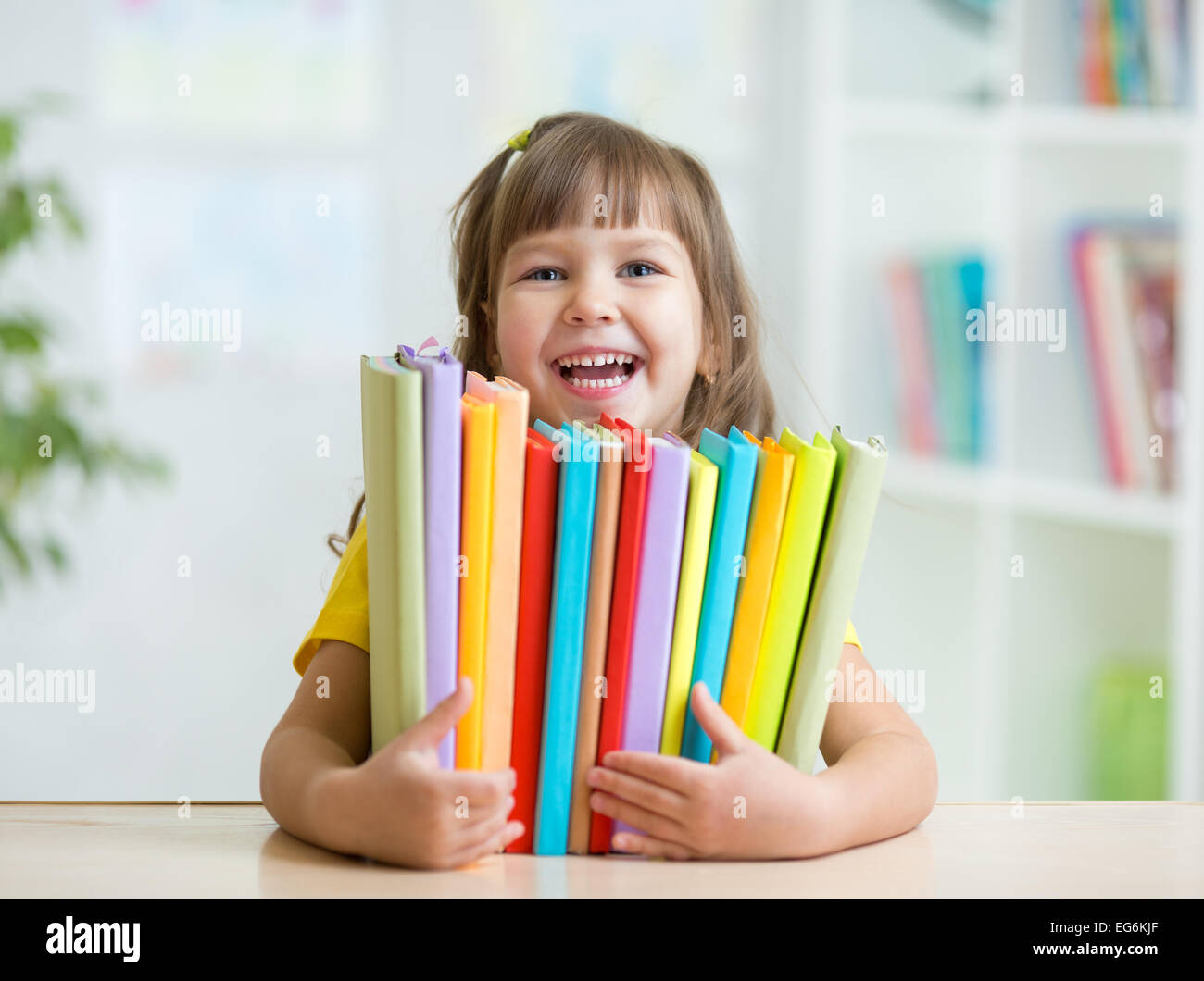 Cute kid girl preschooler with books indoor Stock Photo - Alamy