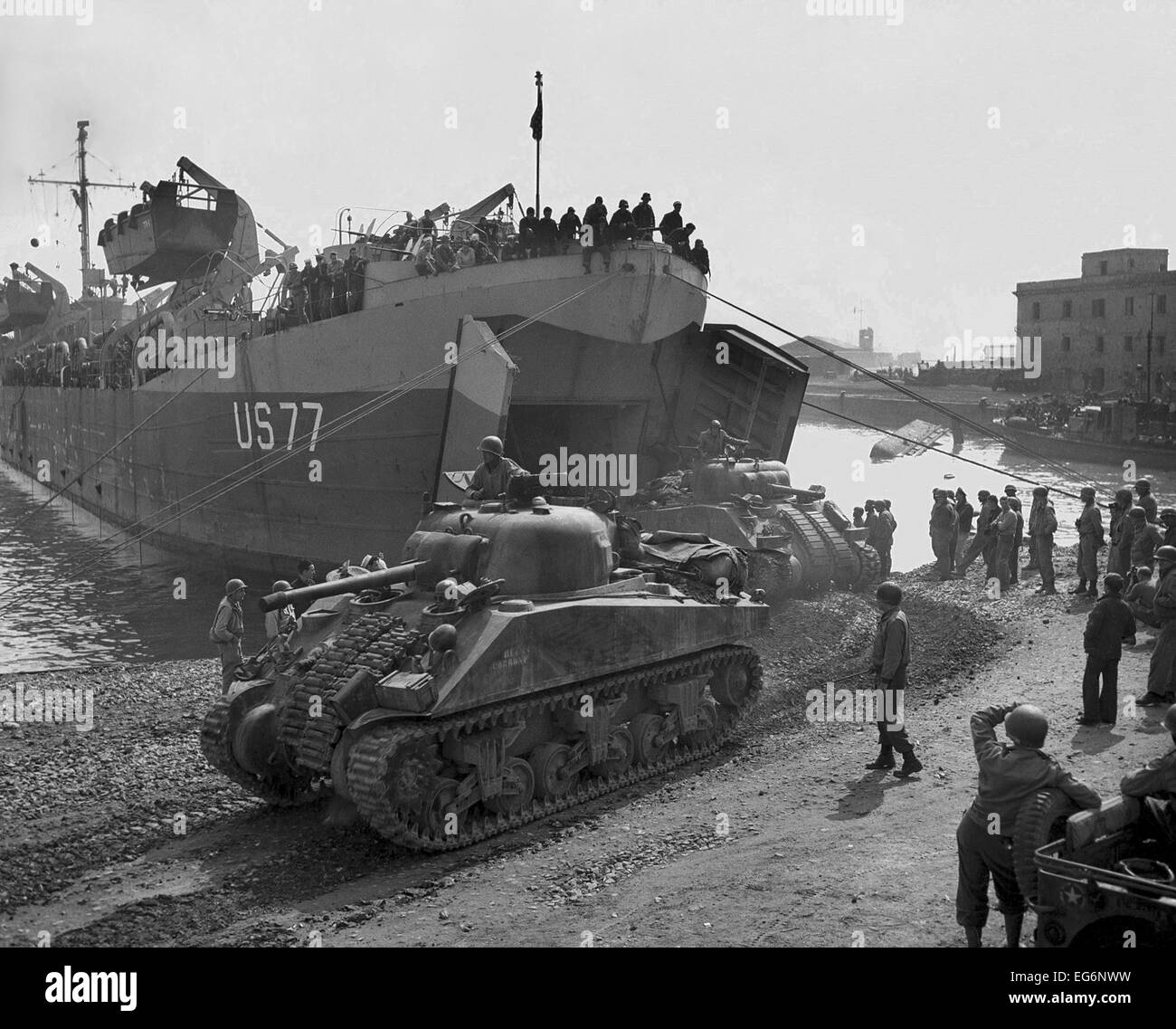 U.S. Sherman tanks leave a landing ship in Anzio harbor, May 1944. While costly combat continued, U.S. Forces built up on the Stock Photo