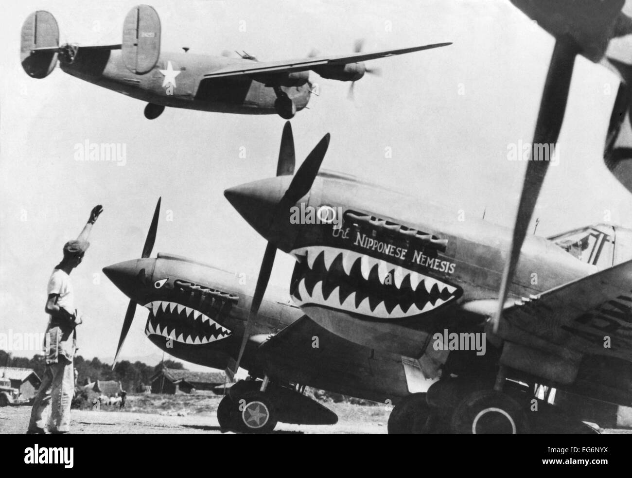An American B-24 Liberator bomber takes off from an advanced U.S. base in China. On the ground are shark nosed P-40 fighters of Stock Photo
