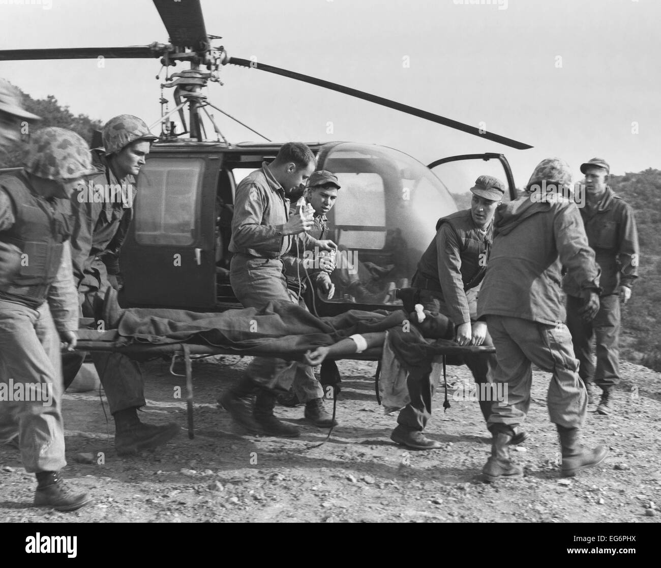 A seriously wounded U.S. Marine is rushed to helicopter by the Corpsmen. He will receive emergency treatment at an aid station Stock Photo