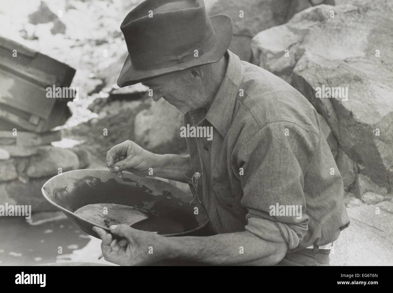 Man panning gold at Pinos Altos, New Mexico. He holds a gold nugget. May-June, 1940. Photo by Russell Lee. (BSLOC 2014 13 236) Stock Photo