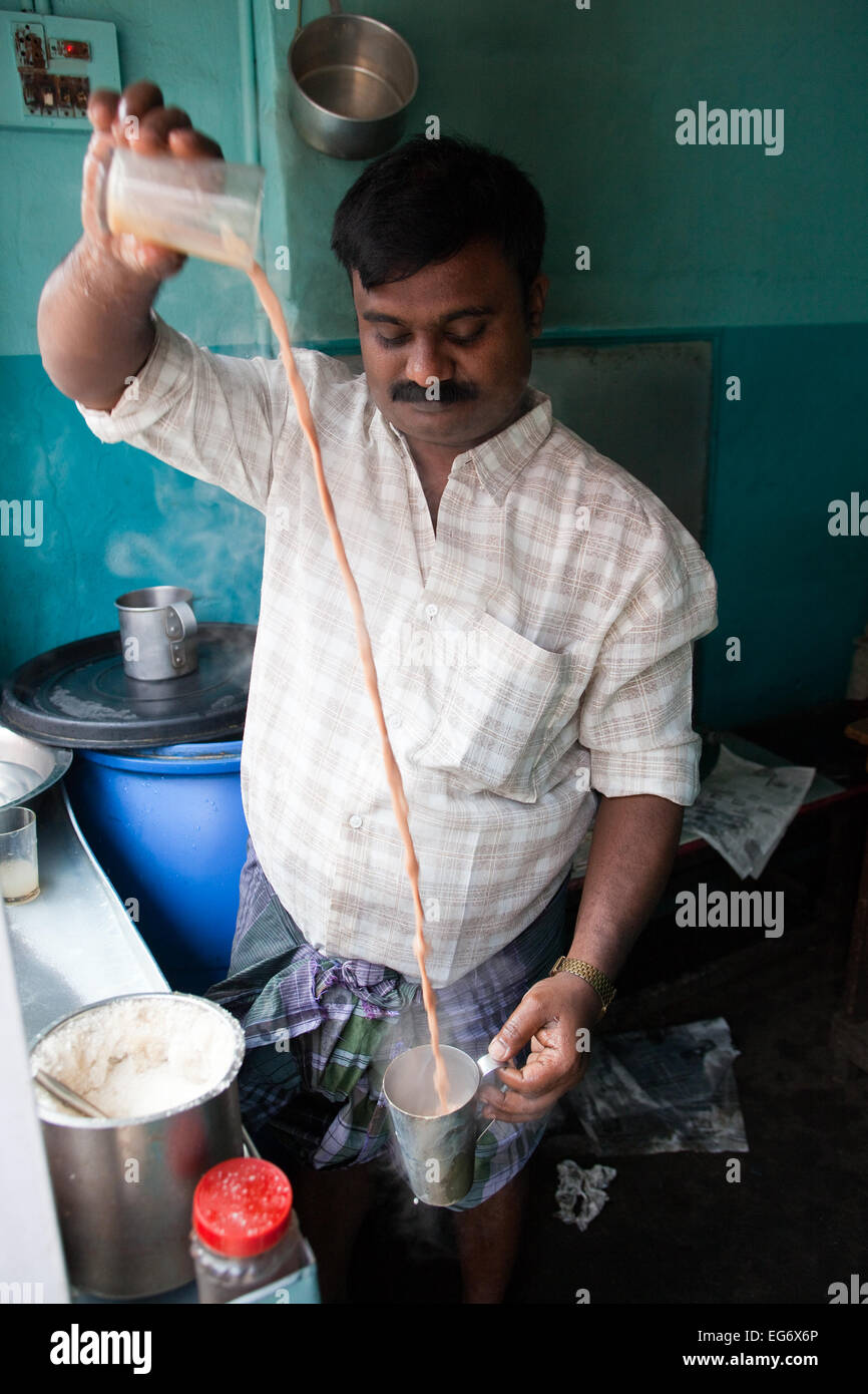 'Chai wallah' or tea maker - tea man pours his chai between glasses before serving to customers, Kumily, Kerala, Southern India Stock Photo