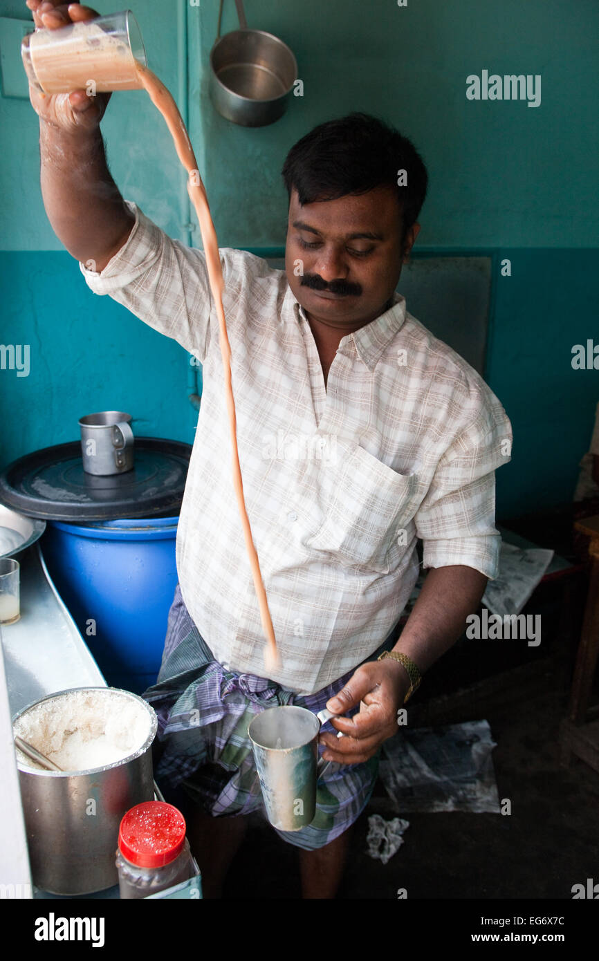 'Chai wallah' or tea maker - tea man pours his chai between glasses before serving to customers, Kumily, Kerala, Southern India Stock Photo