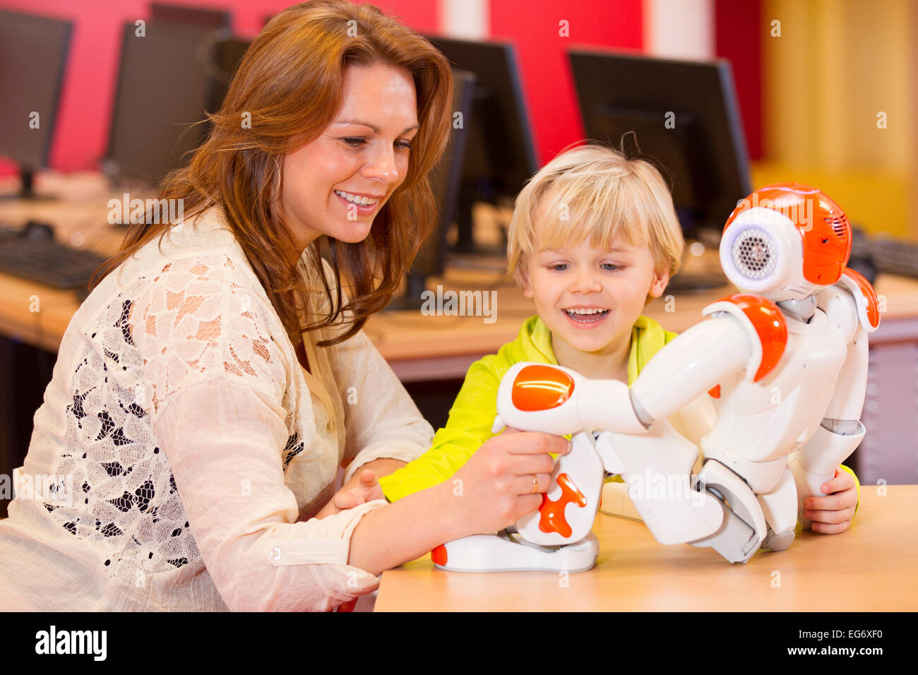 One young boy programming a robot with his science teacher on a primary school Stock Photo