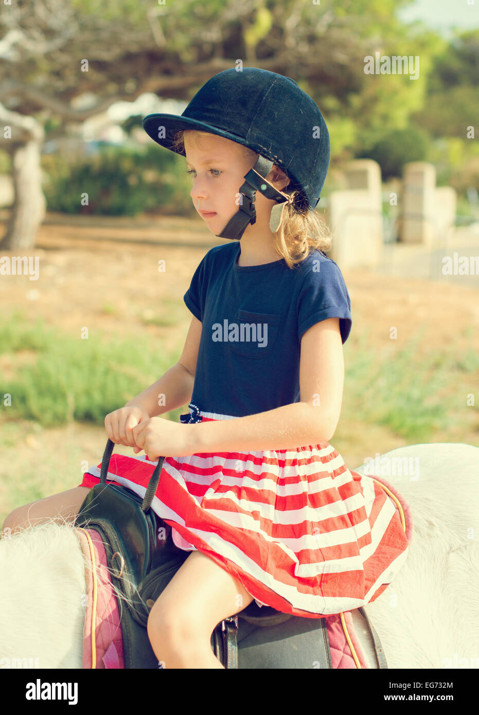 Portrait of little girl riding pony. Stock Photo