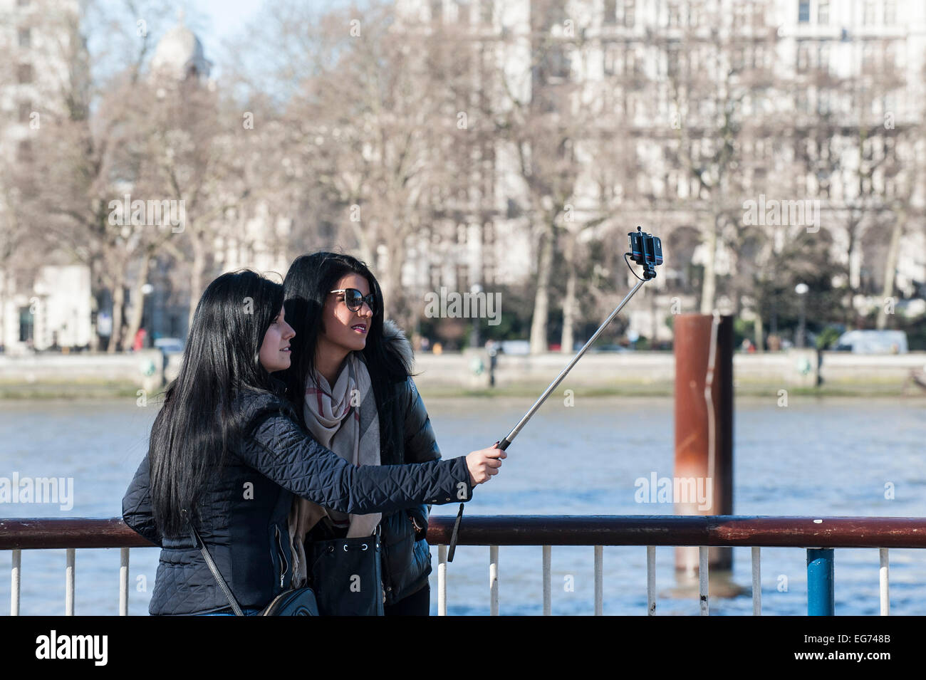 Tourists using a selfie stick on the South Bank in London. Stock Photo