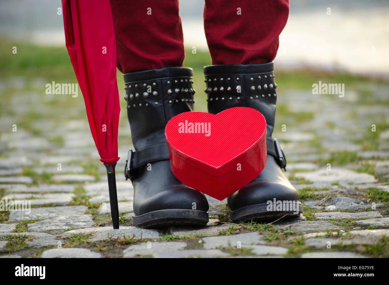 Heart shaped box standing on girl's boots outdoors Stock Photo