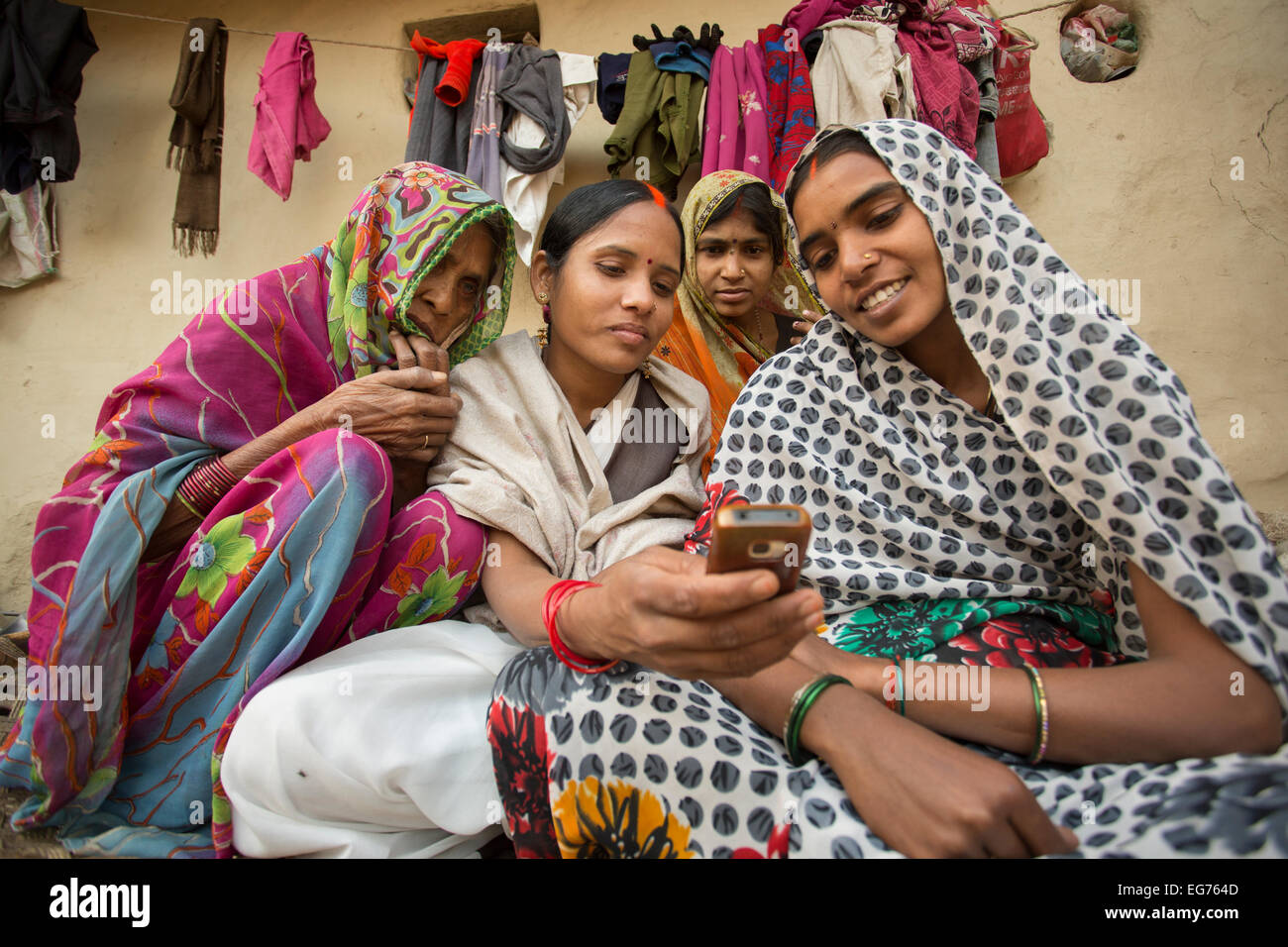 Women look at a mobile phone in Uttar Pradesh, India Stock Photo. 