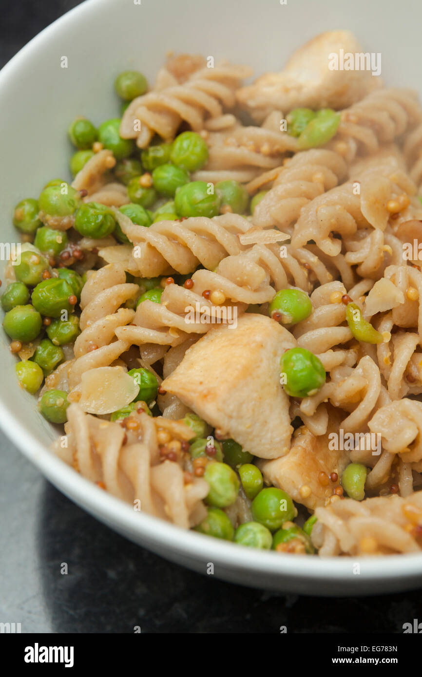 Wholemeal pasta with wholegrain mustard, chicken and peas Stock Photo