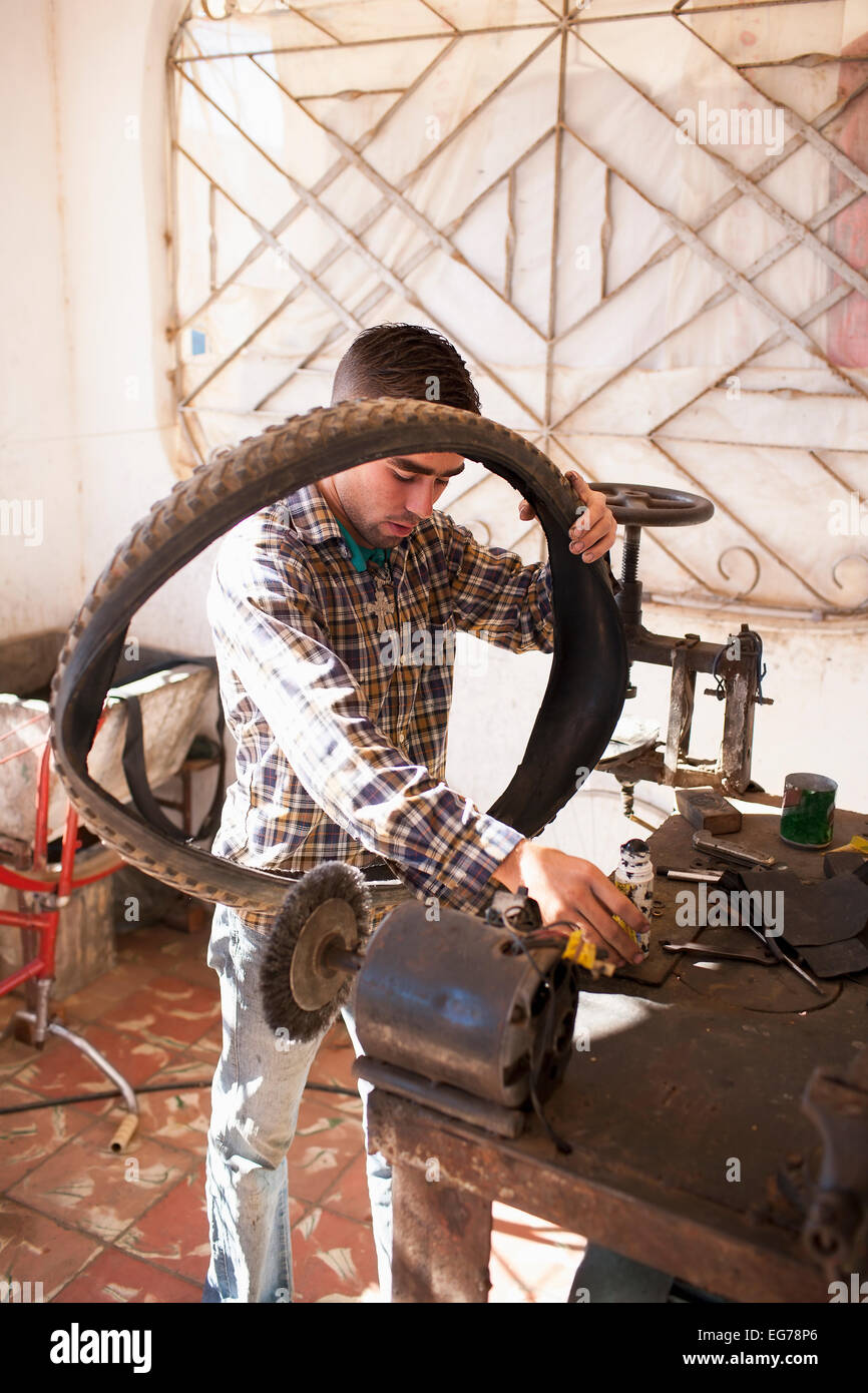 Cuba, Matanzas, Jaguey Grande, young man working at bicycle repair shop Stock Photo