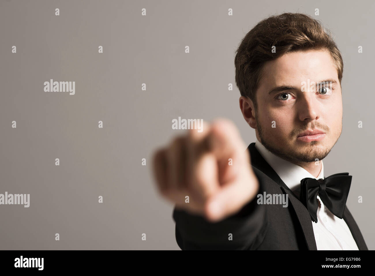 Portrait of man wearing tuxedo and bow pointing on viewer Stock Photo