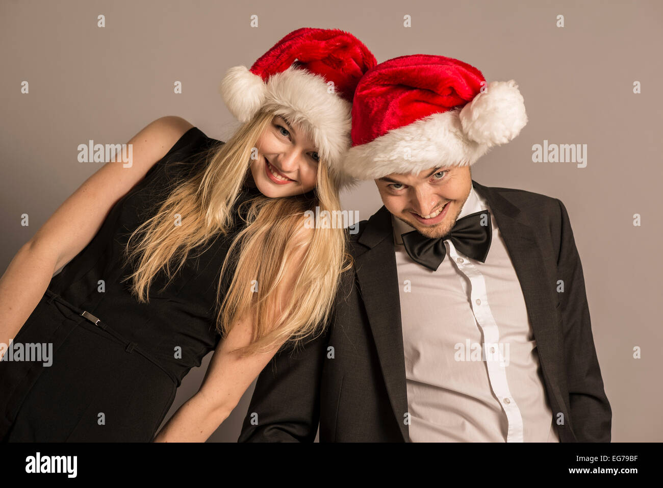 Portrait of well dressed young couple wearing Christmas caps Stock Photo