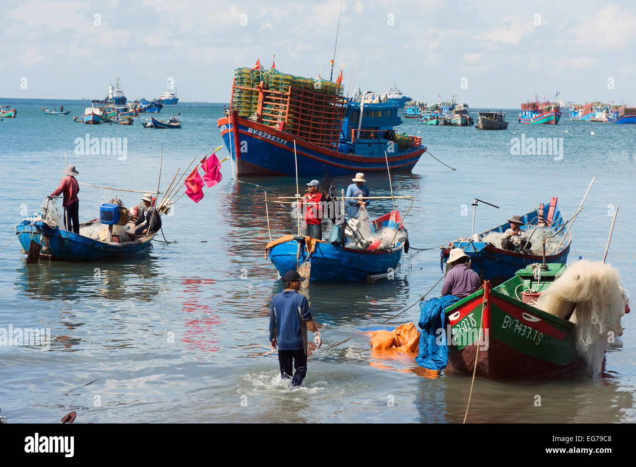 Vietnam, Vung Tau, fishermen sorting nets in harbor Stock Photo