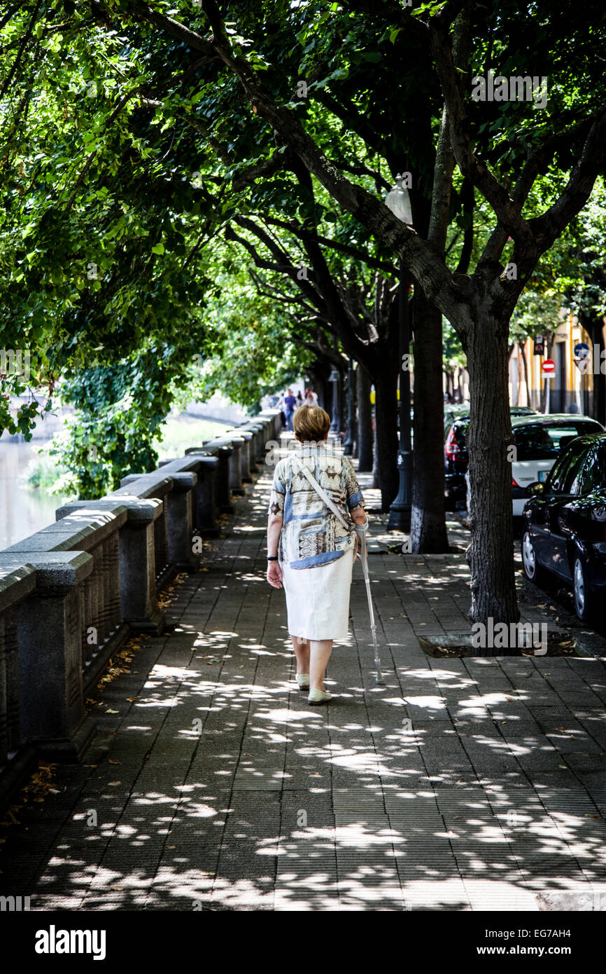 Old woman wlaking by the Onyar River, Girona, Spain. Stock Photo