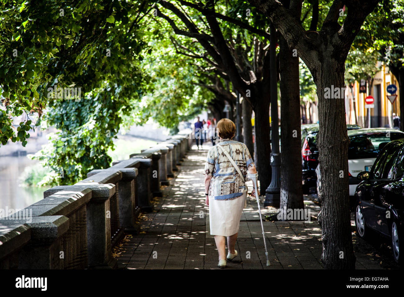 Old woman wlaking by the Onyar River, Girona, Spain. Stock Photo