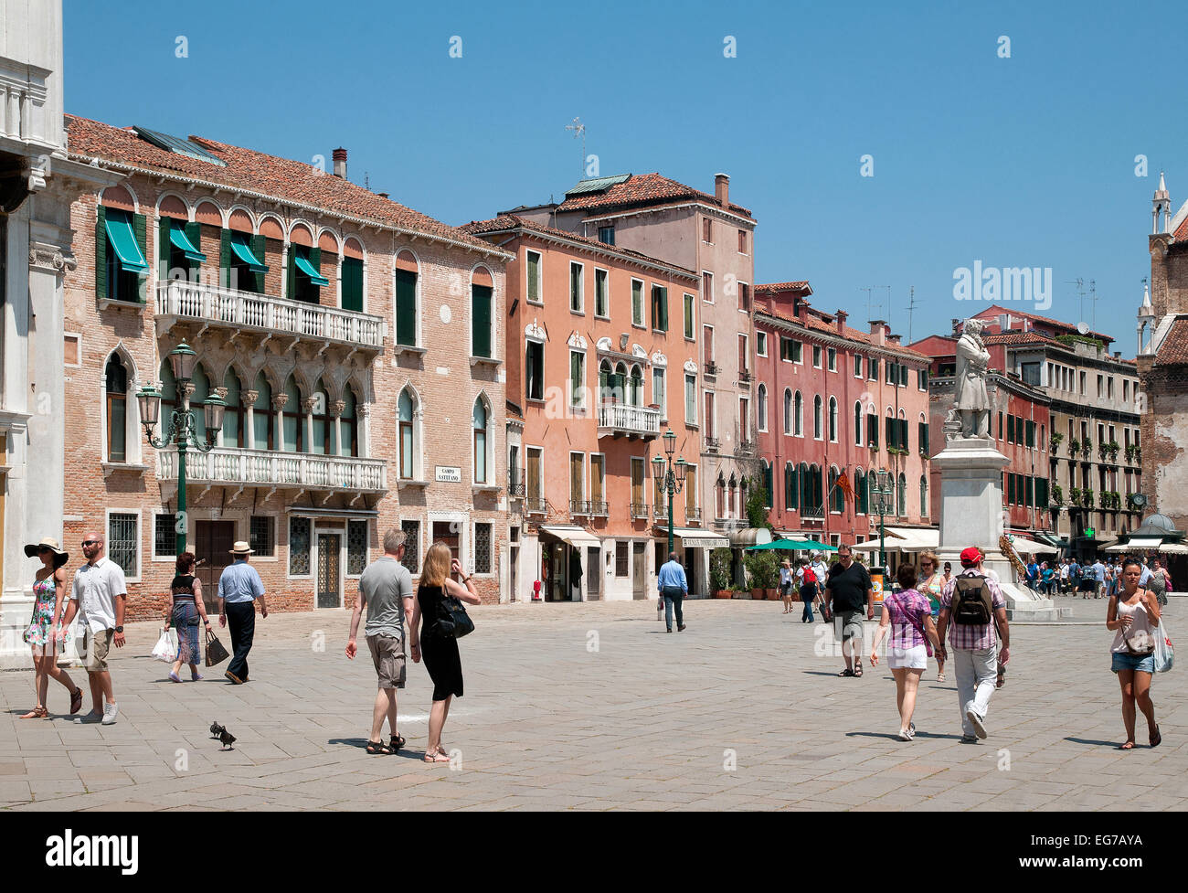 People in summer clothes enjoying June sunshine in Campo San Stefano Venice Italy  Statue of Niccolo Tommaseo is in the square Stock Photo