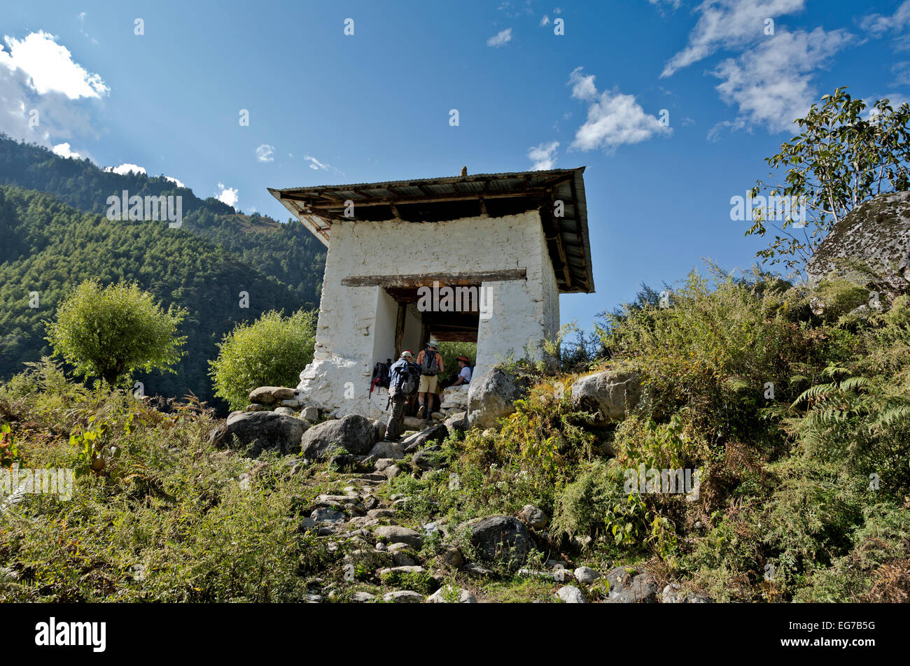 BHUTAN - Hikers on the Jhomolhari 2 Trek taking a break in an archway built to honor the Divine Madman in the Paro Chhu valley. Stock Photo
