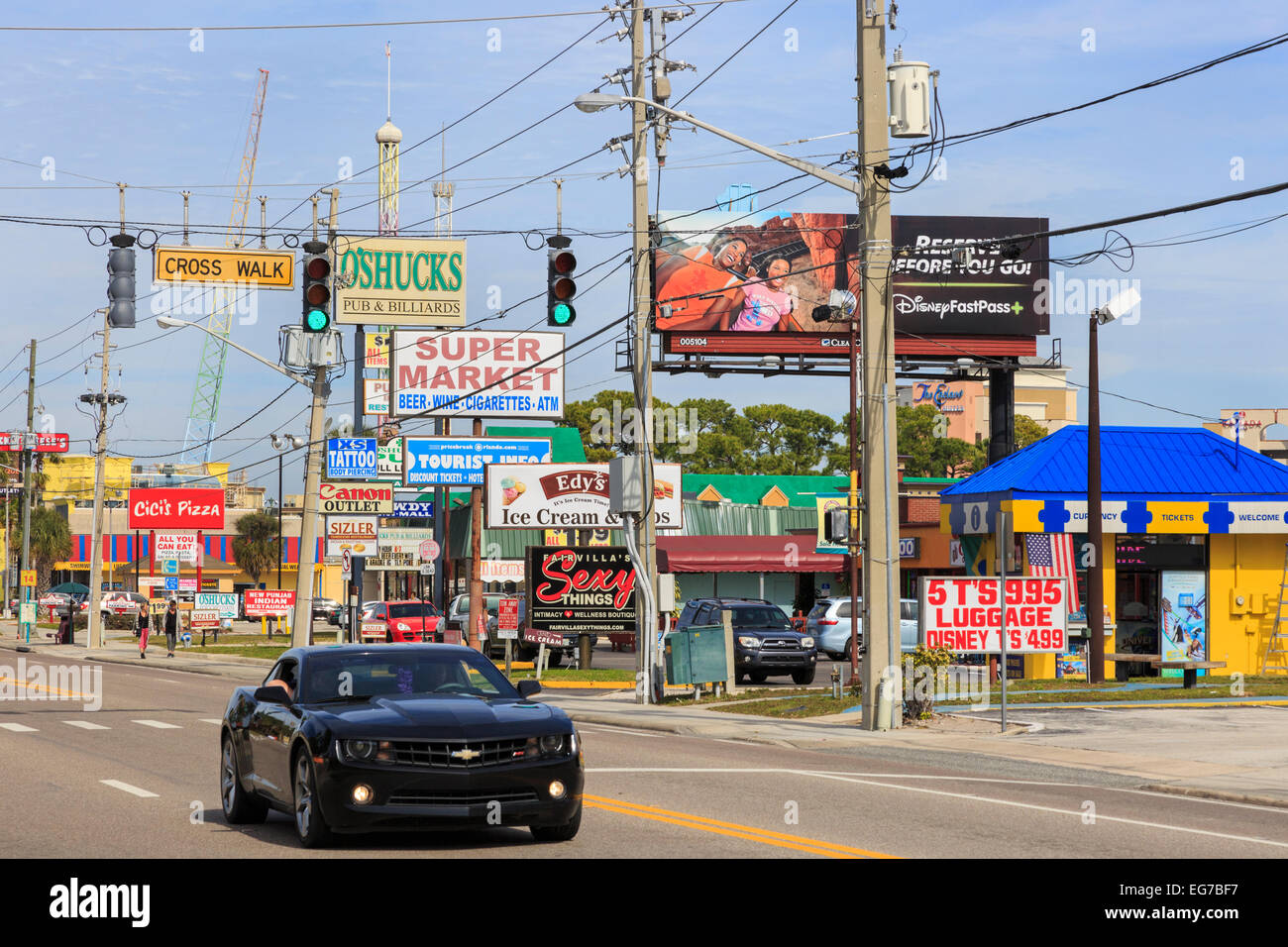 Chevrolet sports car driving on International Drive, Orlando, Florida past rows of advertising billboards, America. Stock Photo